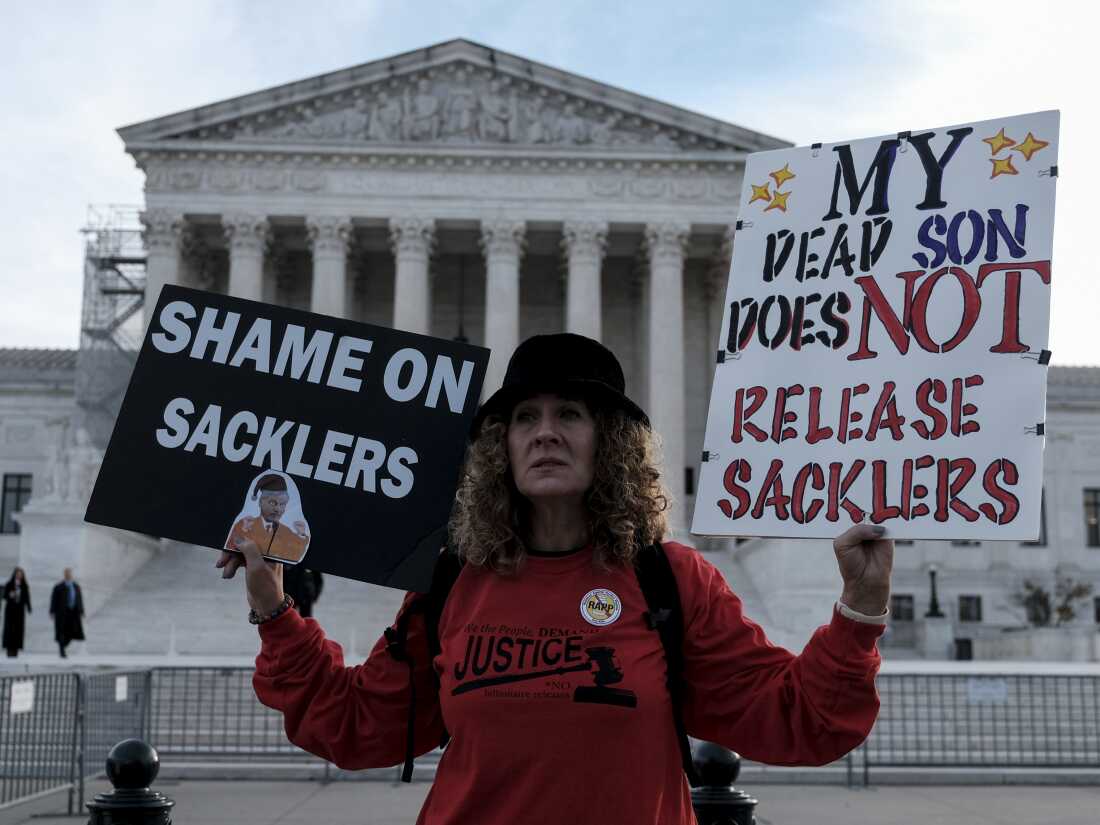 Grace Bisch holds a photo of her son Eddie Bisch, who died of an overdose, while protesting during oral arguments Dec. 4 at the Supreme Court in Washington, D.C. The Supreme Court's June 26 ruling overturned a proposed nationwide settlement with Purdue Pharma.  the maker of OxyContin.  Members of the Sackler family, who owned the company, will have to negotiate a new settlement to the opioid impact lawsuits.